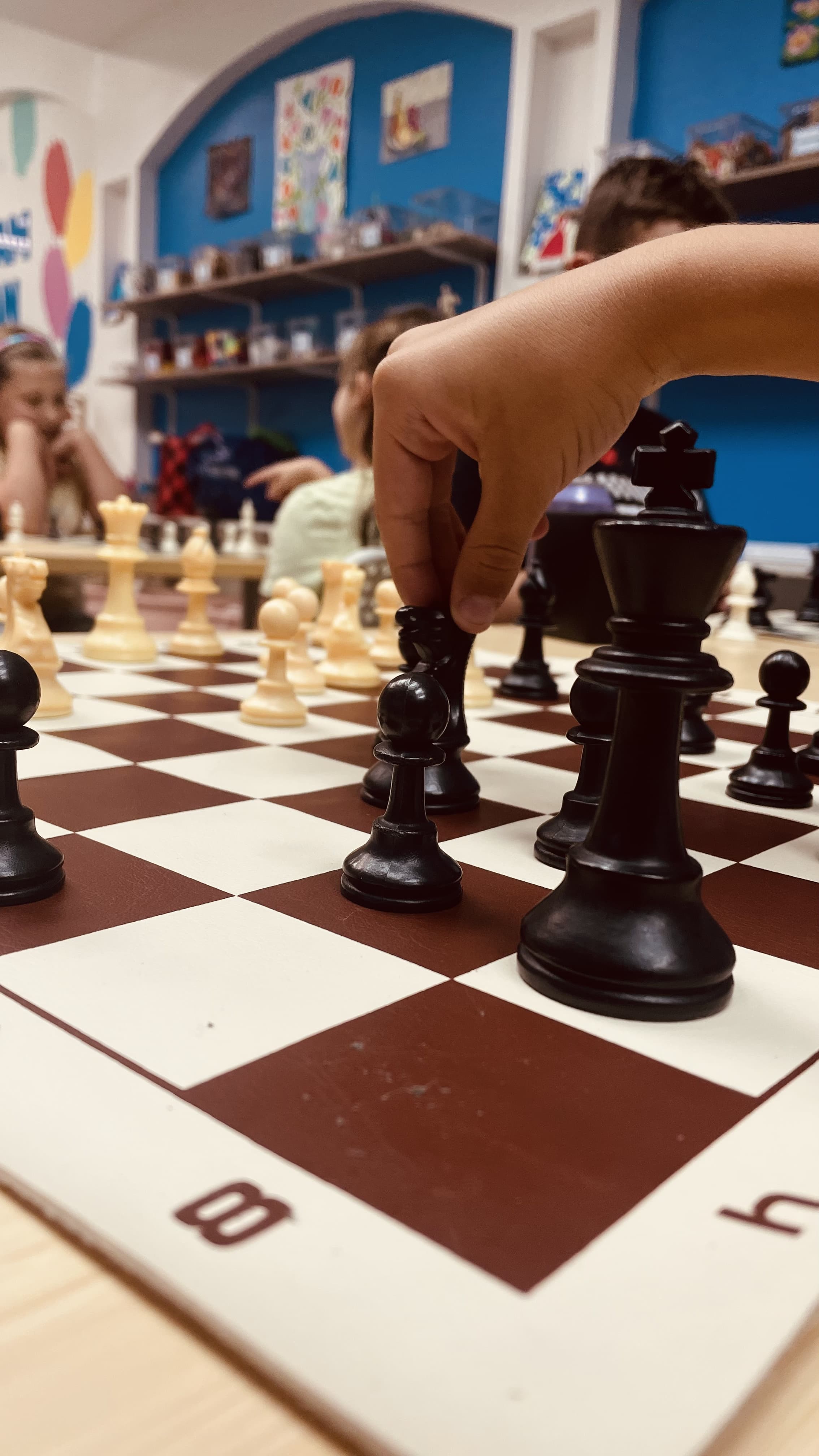A close-up of a chess game in progress at Hot Potato Art Studio